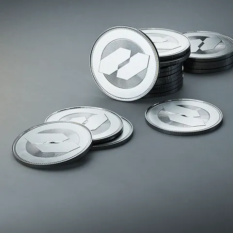 A small pile of silver Credits coins stamped with the HEAT emblem